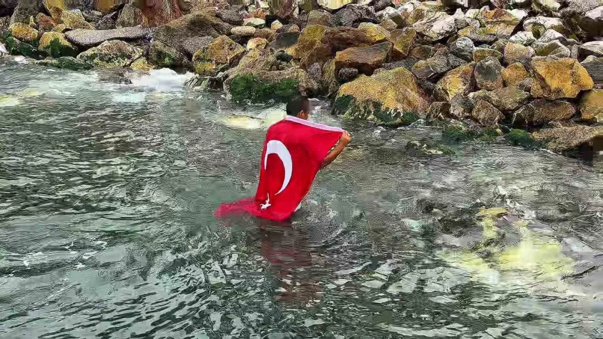 Gemlik'te Şahin Sevinç Türk bayrağıyla denize girdi